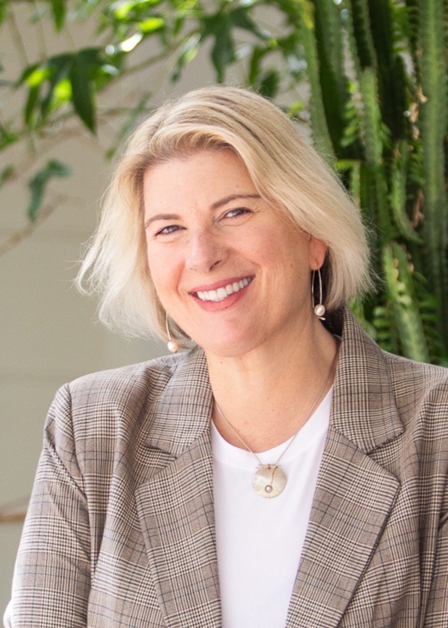 Kathryn Giudes, Founder and CEO of ORCA Opti, smiling, in a check blazer outdoors