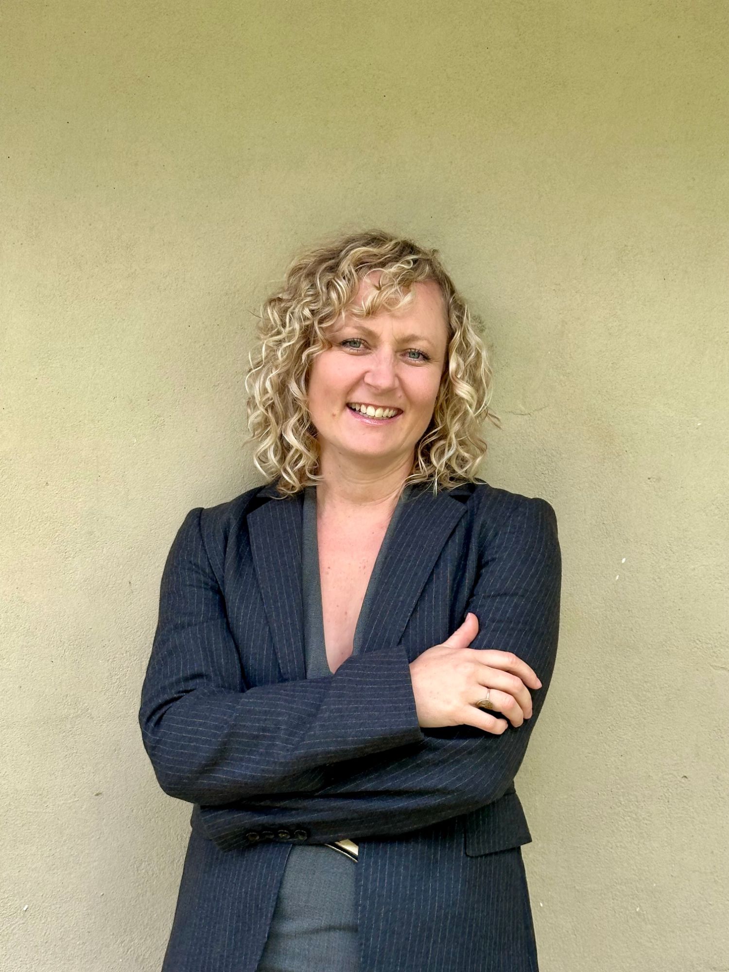 Paige Harkness, Chief Operating Officer of ORCA Opti, smiling, in a pinstripe blazer